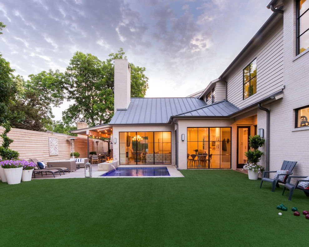 Large contemporary backyard patio in Dallas with a fire feature, decking and an awning.
