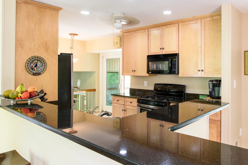 Example of a small transitional galley porcelain tile eat-in kitchen design in DC Metro with an undermount sink, flat-panel cabinets, light wood cabinets, granite countertops, black backsplash, stainless steel appliances and no island