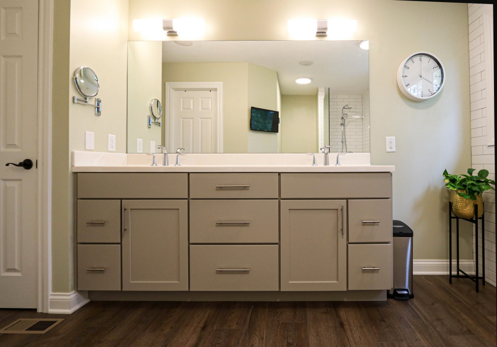 Photo of a mid-sized transitional master bathroom in Cleveland with flat-panel cabinets, grey cabinets, a corner shower, a two-piece toilet, white tile, green walls, laminate floors, an integrated sink, solid surface benchtops, blue floor, an open shower, beige benchtops, a double vanity and a freestanding vanity.
