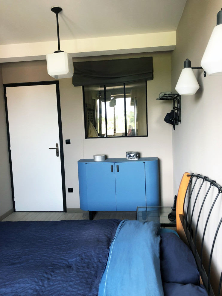 Immagine di una camera da letto minimal di medie dimensioni con pareti beige, pavimento in laminato e pavimento beige