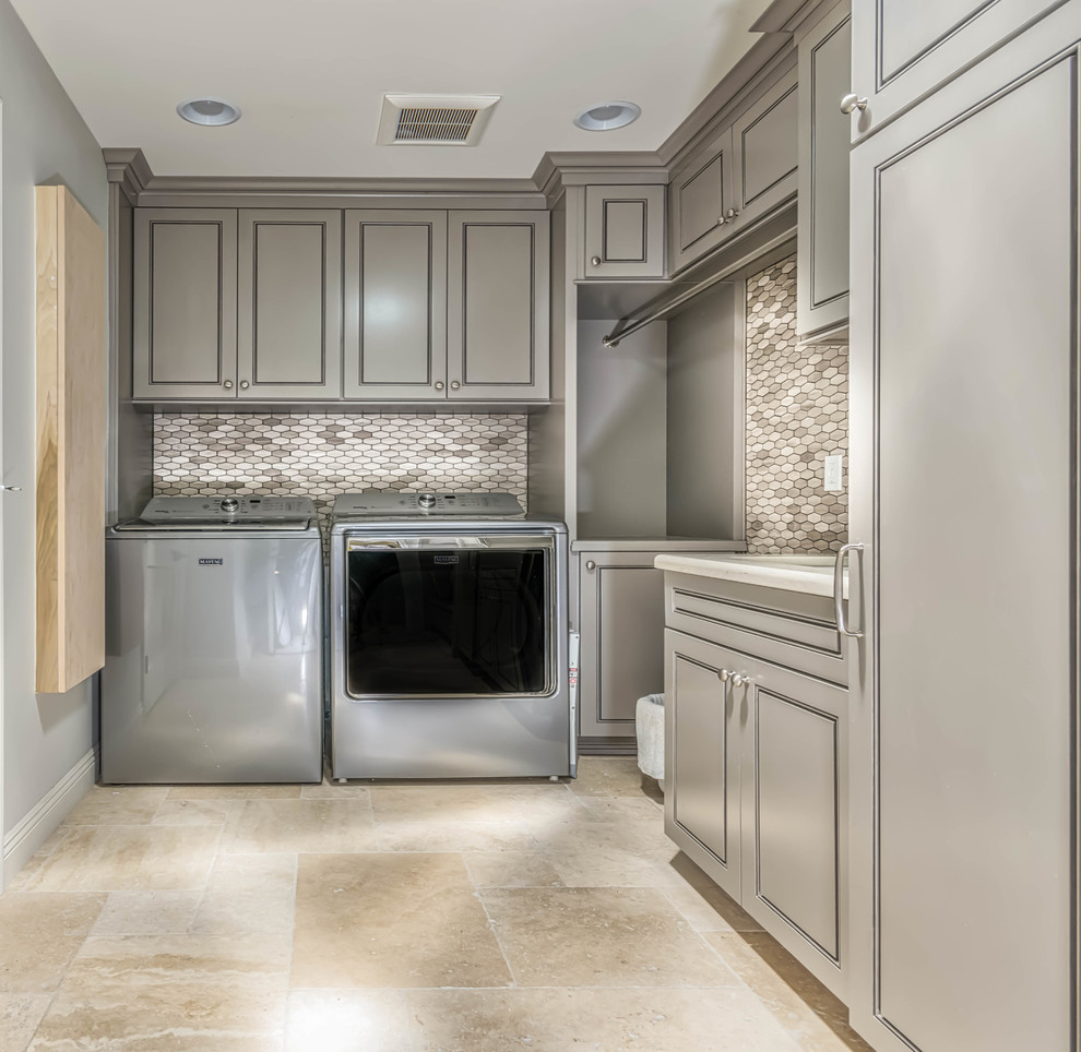 Photo of a large l-shaped dedicated laundry room in Phoenix with an undermount sink, grey cabinets, quartz benchtops, grey walls, travertine floors, a side-by-side washer and dryer and beaded inset cabinets.