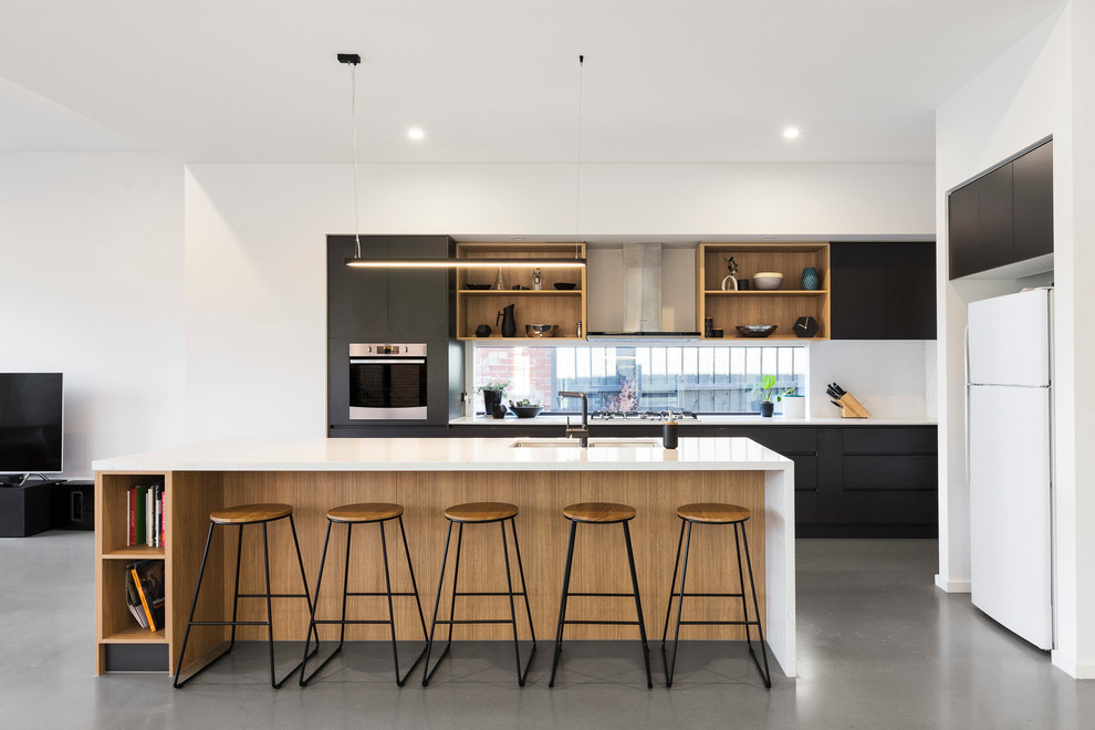 Photo of a scandinavian open plan kitchen in Melbourne with a double-bowl sink, flat-panel cabinets, black cabinets, window splashback, white appliances, concrete floors, with island, grey floor and white benchtop.