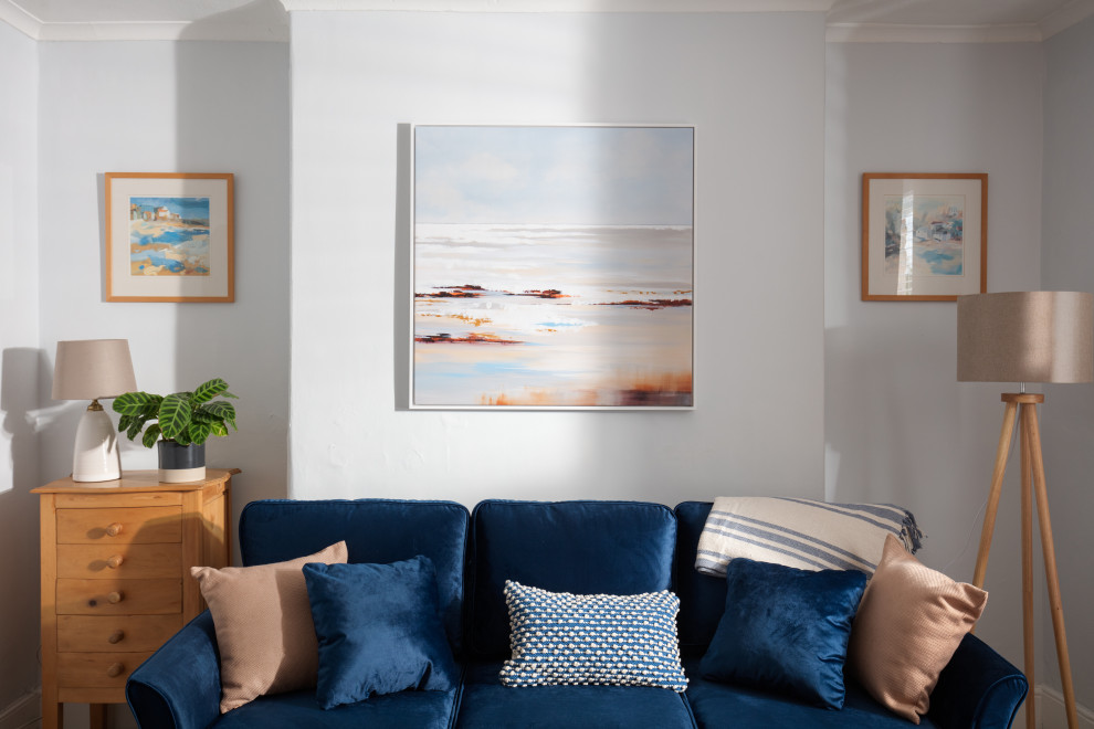 This is an example of a small nautical formal enclosed living room in Cornwall with blue walls, carpet, no fireplace, a corner tv, beige floors and a chimney breast.