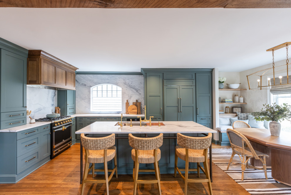 Kitchen - transitional l-shaped medium tone wood floor and brown floor kitchen idea in Charleston with an undermount sink, shaker cabinets, green cabinets, gray backsplash, stone slab backsplash, paneled appliances, an island and white countertops