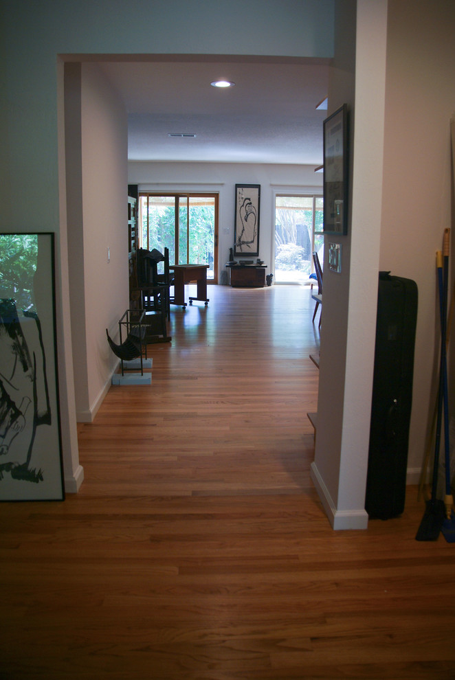 Inspiration for a small contemporary hallway in Sacramento with white walls and medium hardwood floors.