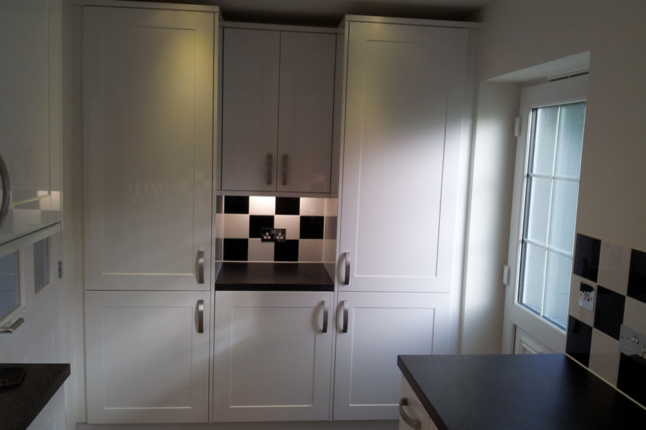 Photo of a small contemporary u-shaped separate kitchen in Hampshire with a drop-in sink, shaker cabinets, white cabinets, granite benchtops, multi-coloured splashback, ceramic splashback, stainless steel appliances and no island.