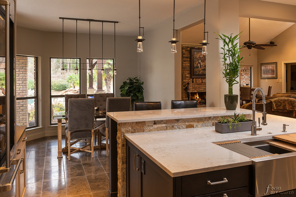 Example of a mid-sized transitional u-shaped enclosed kitchen design in Dallas with an undermount sink, flat-panel cabinets, light wood cabinets, stone tile backsplash, stainless steel appliances and an island