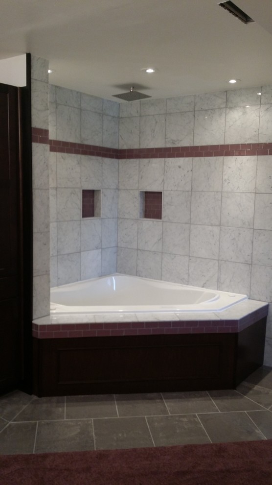 Example of a mid-sized transitional master multicolored tile and stone tile porcelain tile corner bathtub design with raised-panel cabinets and dark wood cabinets