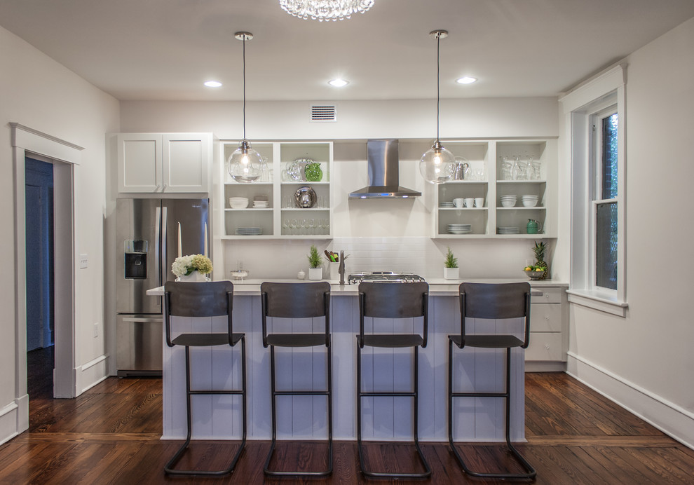 Small transitional galley eat-in kitchen in Atlanta with a double-bowl sink, shaker cabinets, white cabinets, quartz benchtops, white splashback, subway tile splashback, stainless steel appliances, medium hardwood floors, with island and brown floor.