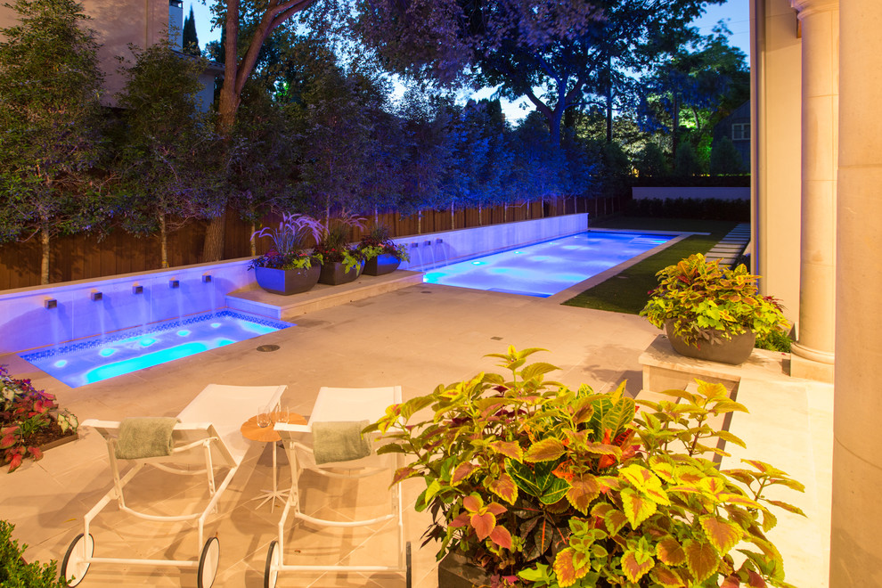 This is an example of a large mediterranean backyard rectangular lap pool in Dallas with natural stone pavers.