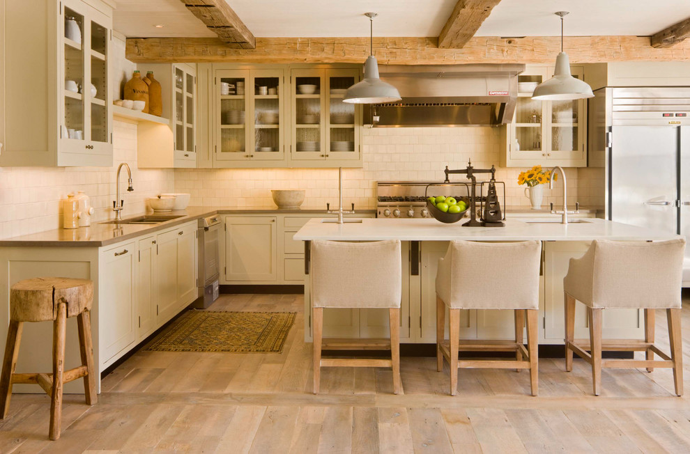Inspiration for a country l-shaped kitchen in Denver with a double-bowl sink, glass-front cabinets, beige cabinets, beige splashback and stainless steel appliances.