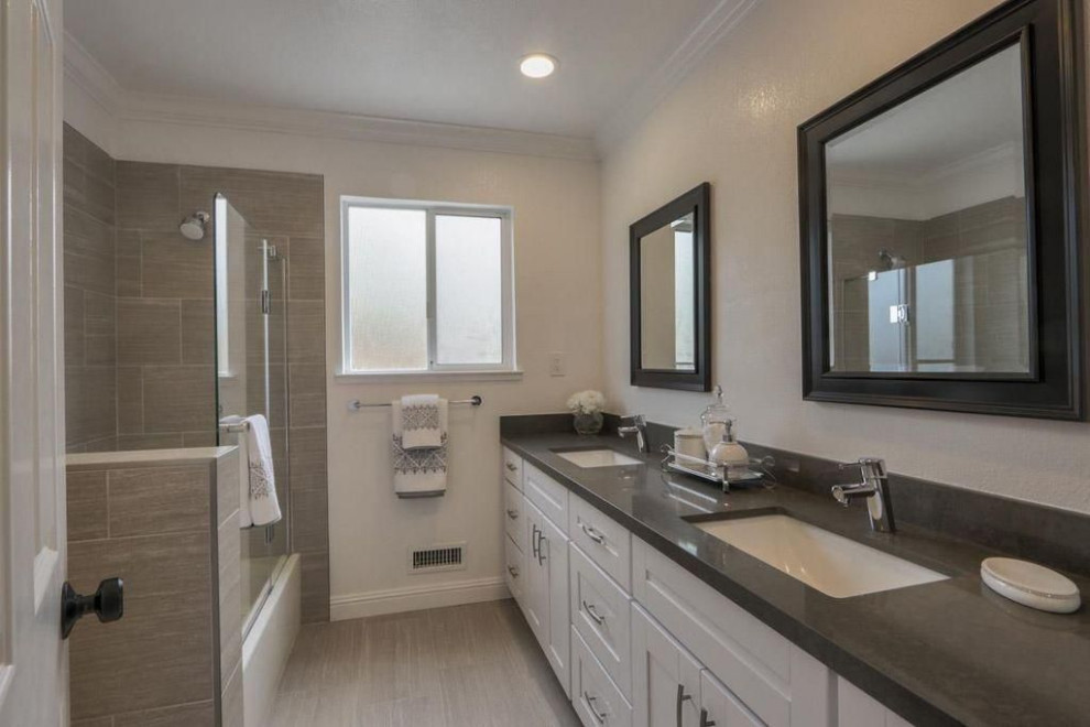 This is an example of a mid-sized transitional kids bathroom in San Francisco with shaker cabinets, white cabinets, a corner tub, a corner shower, a one-piece toilet, beige tile, ceramic tile, beige walls, ceramic floors, an undermount sink, engineered quartz benchtops, beige floor, a sliding shower screen and grey benchtops.
