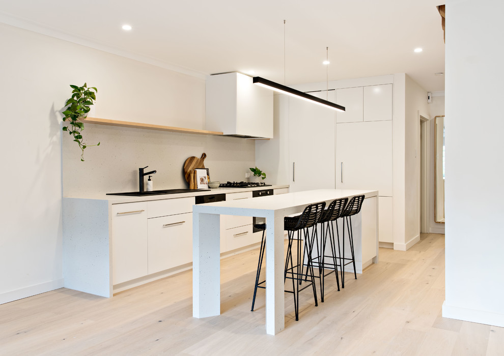 Design ideas for a mid-sized contemporary galley eat-in kitchen in Sydney with a drop-in sink, white cabinets, quartz benchtops, white splashback, panelled appliances, with island and white benchtop.