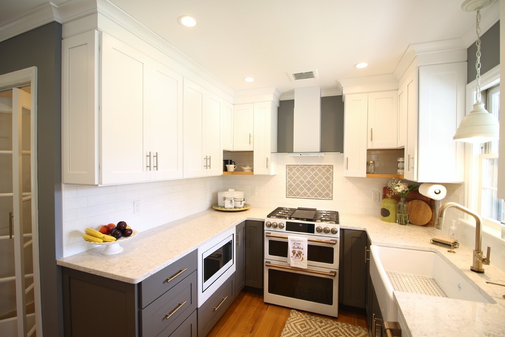 Inspiration for a mid-sized transitional u-shaped medium tone wood floor and brown floor enclosed kitchen remodel with a farmhouse sink, shaker cabinets, white cabinets, quartz countertops, white backsplash, subway tile backsplash, white appliances, no island and beige countertops