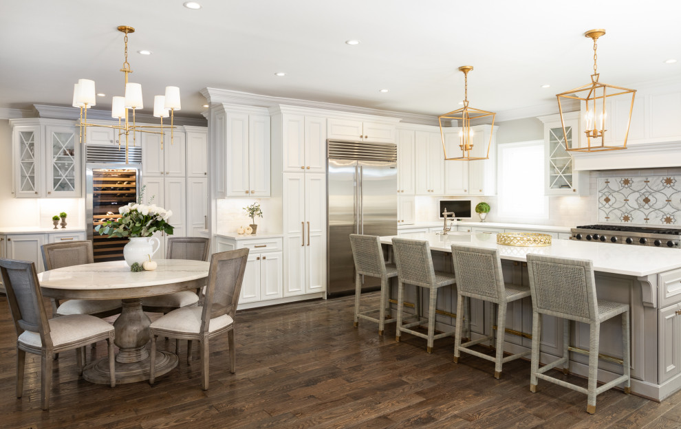 Inspiration for a traditional l-shaped eat-in kitchen in DC Metro with recessed-panel cabinets, white cabinets, multi-coloured splashback, stainless steel appliances, dark hardwood floors, with island, brown floor and white benchtop.