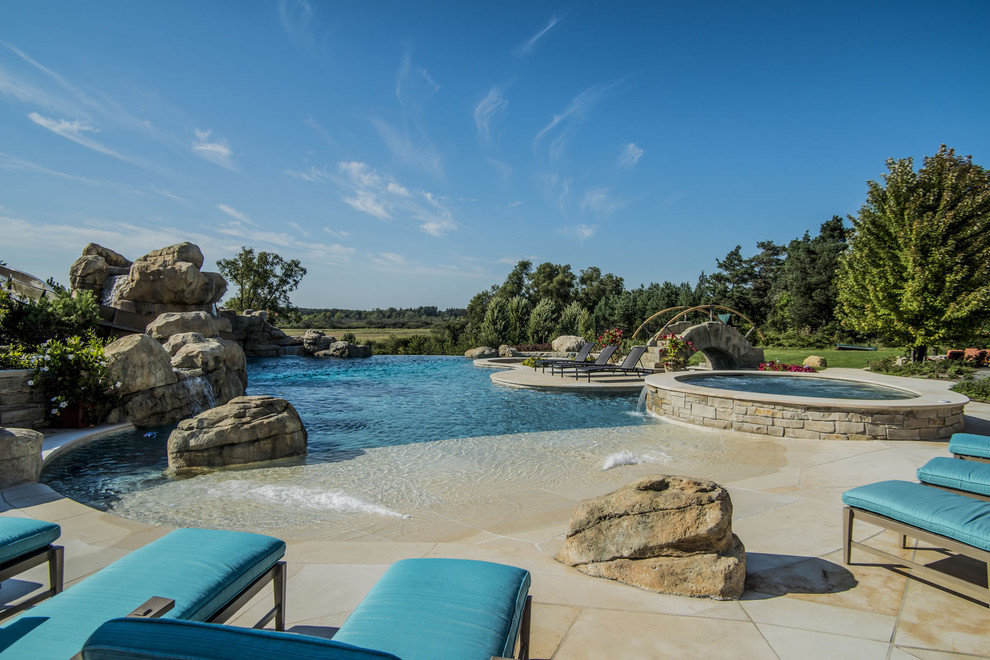 Hot tub - huge backyard stone and custom-shaped infinity hot tub idea in Chicago