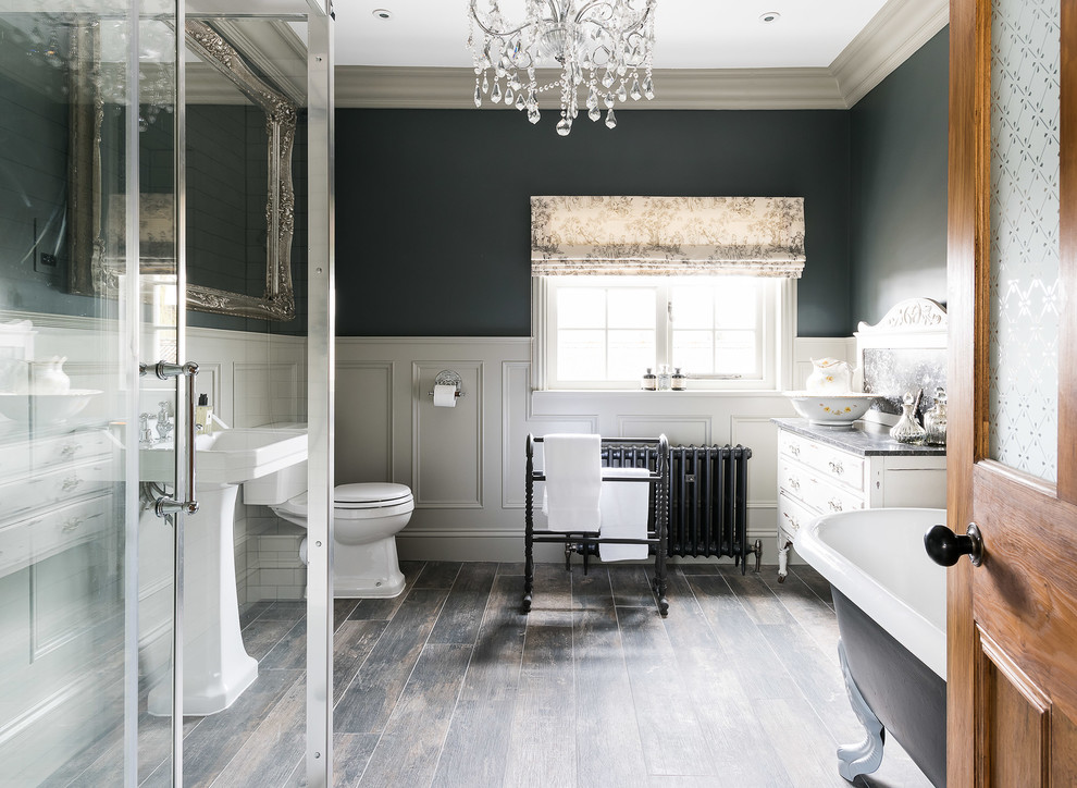Design ideas for a large traditional bathroom in Other with a claw-foot tub, a corner shower, a one-piece toilet, white tile, ceramic tile, grey walls, a pedestal sink, marble benchtops, a hinged shower door and flat-panel cabinets.