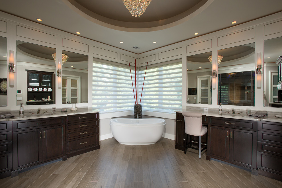 Expansive contemporary master bathroom in DC Metro with an undermount sink, furniture-like cabinets, black cabinets, granite benchtops, a freestanding tub, an alcove shower, a one-piece toilet, gray tile, porcelain tile, grey walls and porcelain floors.