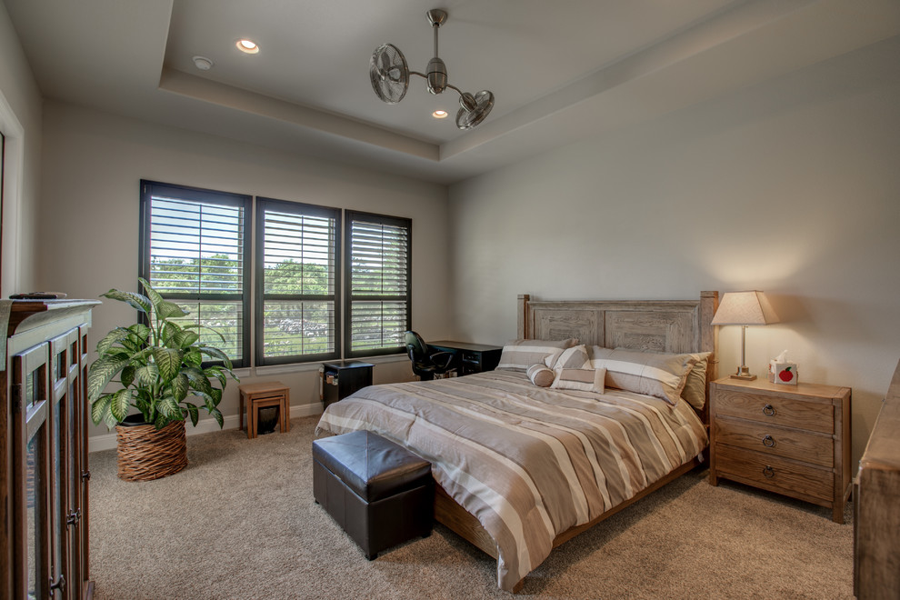 Inspiration for a mid-sized country master bedroom in Austin with beige walls, carpet, no fireplace and beige floor.