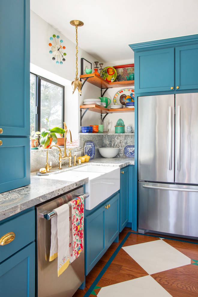 Example of an eclectic kitchen design in Los Angeles with a farmhouse sink, shaker cabinets, blue cabinets, granite countertops and stainless steel appliances