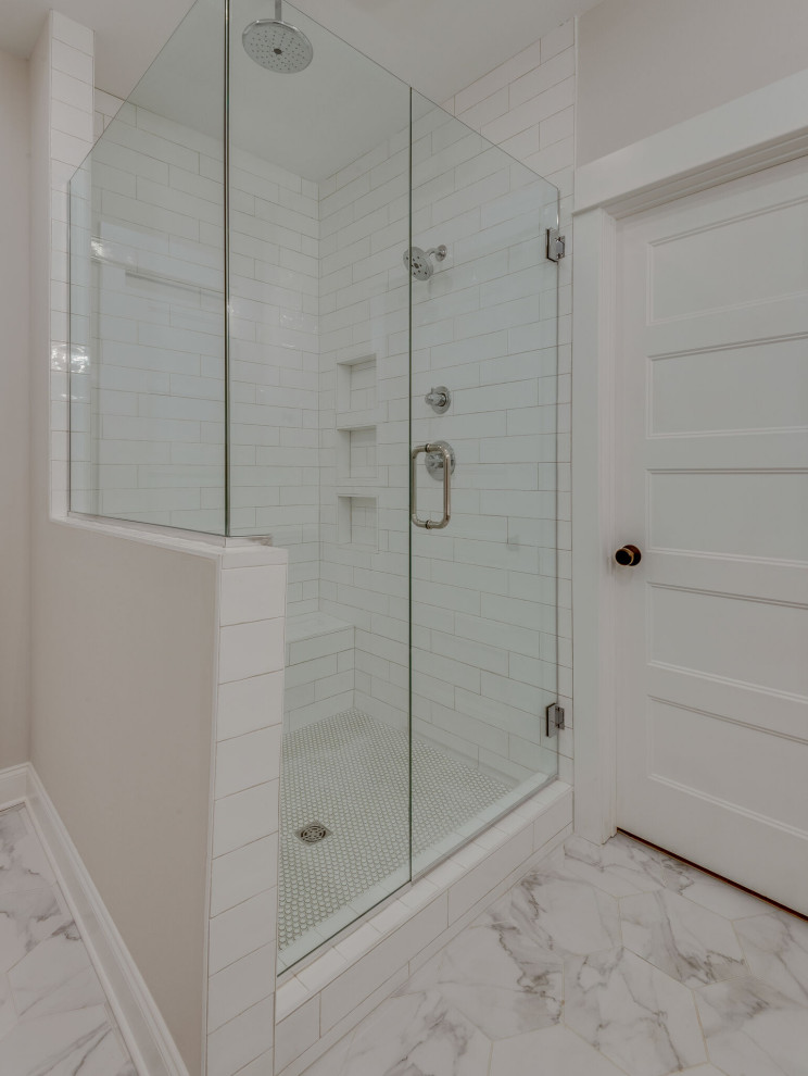 This is an example of a master bathroom in Nashville with an alcove shower, white tile, ceramic tile, grey walls, light hardwood floors, an undermount sink, engineered quartz benchtops, a hinged shower door, a niche and a double vanity.