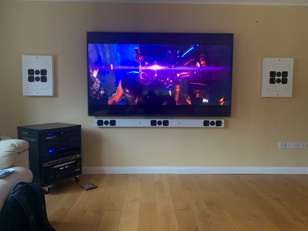 Photo of a medium sized traditional enclosed home cinema in Hampshire with beige walls, light hardwood flooring, a wall mounted tv and beige floors.