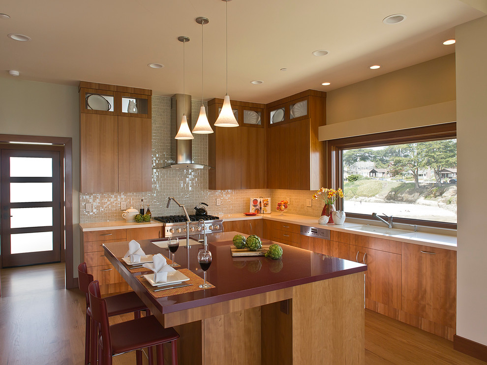 Mid-sized contemporary u-shaped eat-in kitchen in San Francisco with a single-bowl sink, flat-panel cabinets, medium wood cabinets, beige splashback, stainless steel appliances, light hardwood floors and with island.