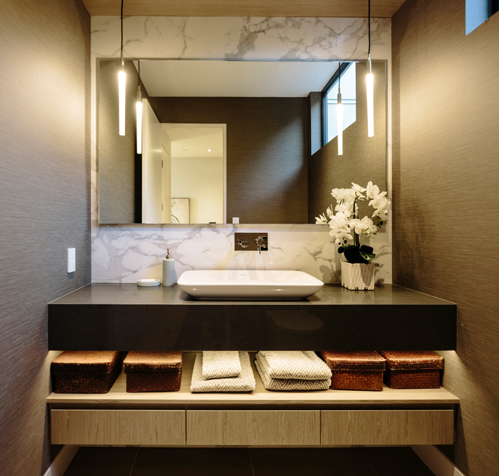 Photo of a large contemporary powder room in Vancouver with flat-panel cabinets, medium wood cabinets, brown tile, porcelain tile, a vessel sink, engineered quartz benchtops and grey benchtops.