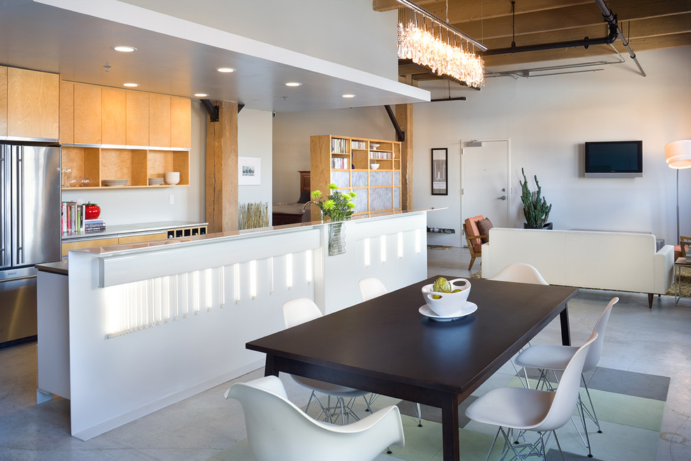This is an example of a contemporary open plan kitchen in Kansas City with flat-panel cabinets and light wood cabinets.