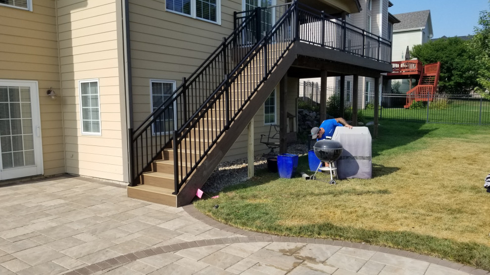 Example of a mid-sized backyard second story privacy and metal railing deck design with a roof extension