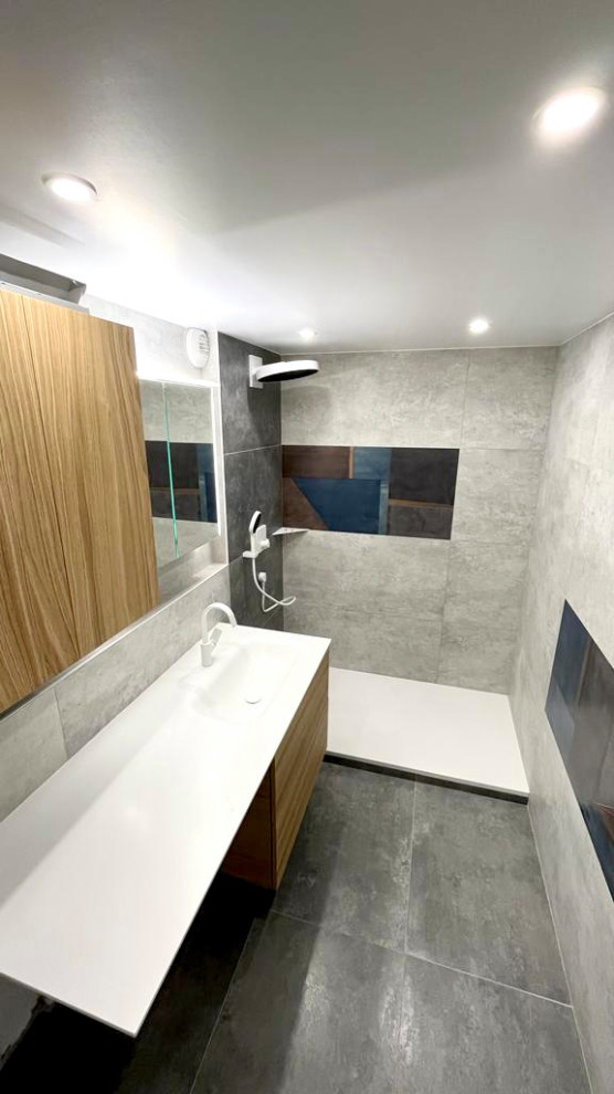 Photo of a medium sized modern ensuite wet room bathroom in Paris with light wood cabinets, grey tiles, grey walls, a trough sink, grey floors, a hinged door, white worktops, a single sink and a floating vanity unit.