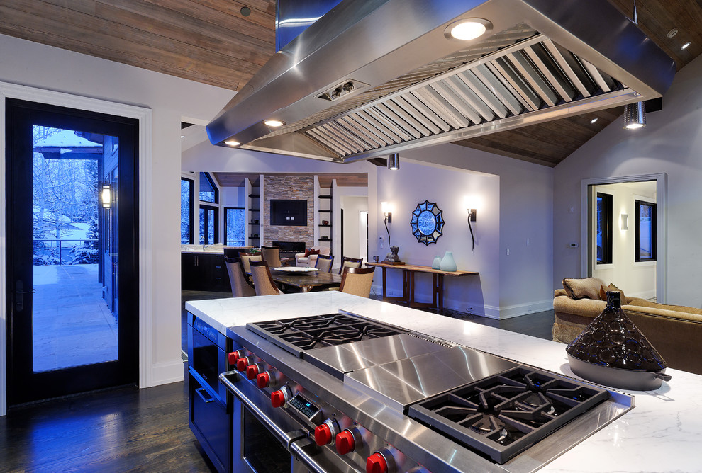 This is an example of a country open plan kitchen in Denver with stainless steel appliances.