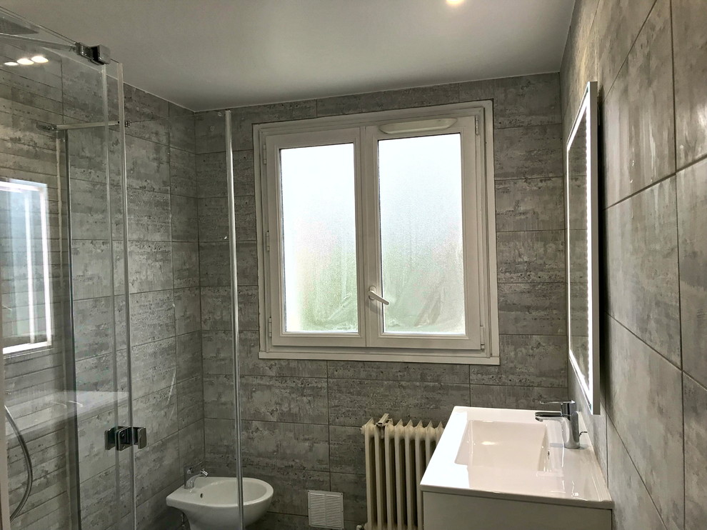 Inspiration for a mid-sized transitional 3/4 bathroom in Paris with beaded inset cabinets, brown cabinets, a freestanding tub, a curbless shower, a bidet, gray tile, ceramic tile, grey walls, ceramic floors, a vessel sink, limestone benchtops, grey floor, a sliding shower screen and white benchtops.
