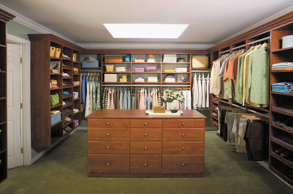 Inspiration for a large traditional gender-neutral walk-in wardrobe in Boston with flat-panel cabinets, medium wood cabinets and carpet.