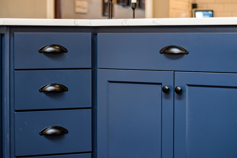 Example of a large transitional u-shaped eat-in kitchen design in Columbus with shaker cabinets, quartz countertops, white backsplash and an island
