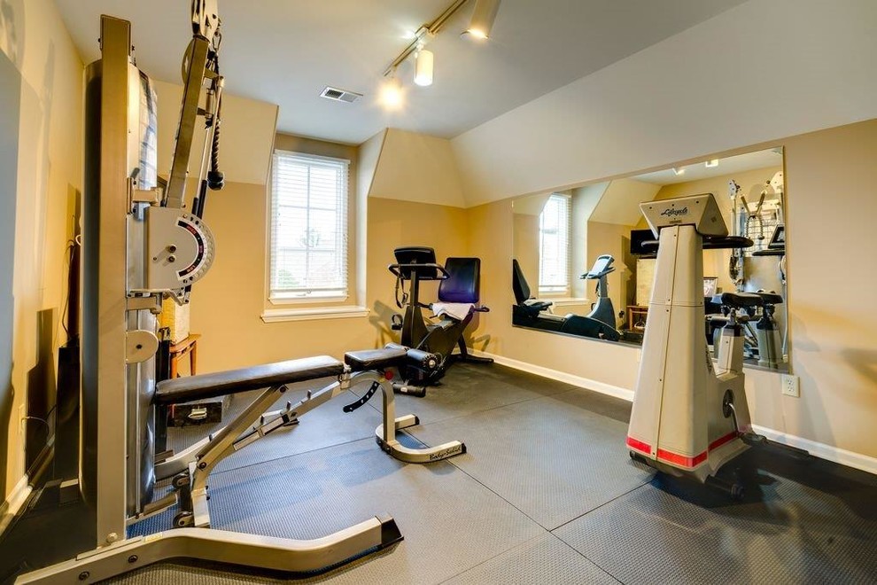 Photo of a mid-sized traditional home weight room in Other with beige walls and grey floor.