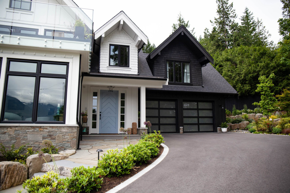 Example of a large farmhouse attached two-car garage workshop design in Vancouver