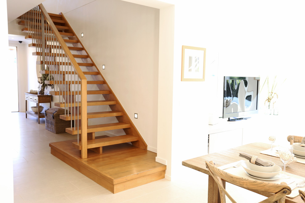 This is an example of a mid-sized contemporary wood straight staircase in Sydney with wood risers and metal railing.