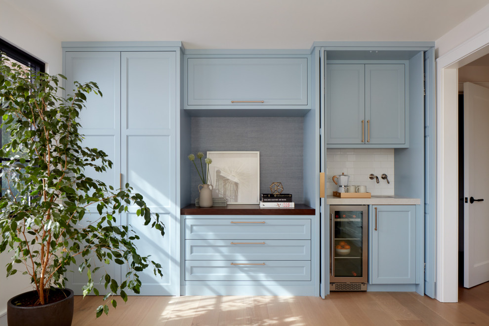 Wet bar - large transitional light wood floor wet bar idea in San Francisco with an undermount sink, shaker cabinets, blue cabinets, solid surface countertops and porcelain backsplash