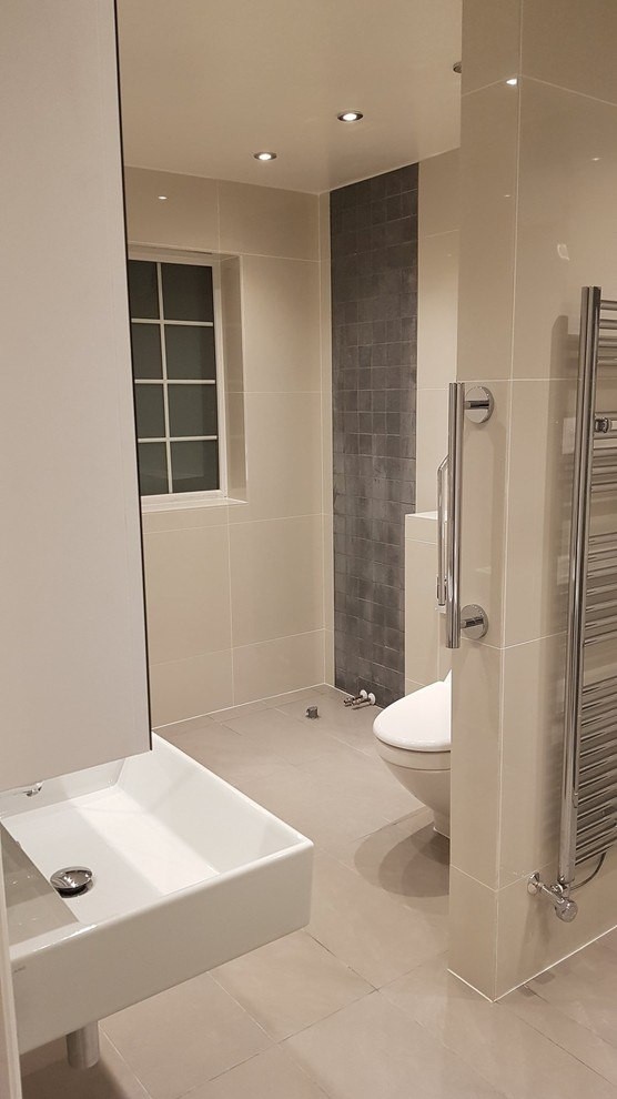 Photo of a mid-sized modern kids bathroom in London with white cabinets, a drop-in tub, a curbless shower, a one-piece toilet, white tile, glass tile, white walls, ceramic floors, a drop-in sink, stainless steel benchtops, white floor, a hinged shower door, grey benchtops, a double vanity, a floating vanity, wood and decorative wall panelling.