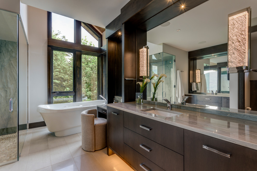 This is an example of a country master bathroom in Detroit with flat-panel cabinets, dark wood cabinets, a freestanding tub, a curbless shower, an undermount sink, beige floor, a hinged shower door and grey benchtops.