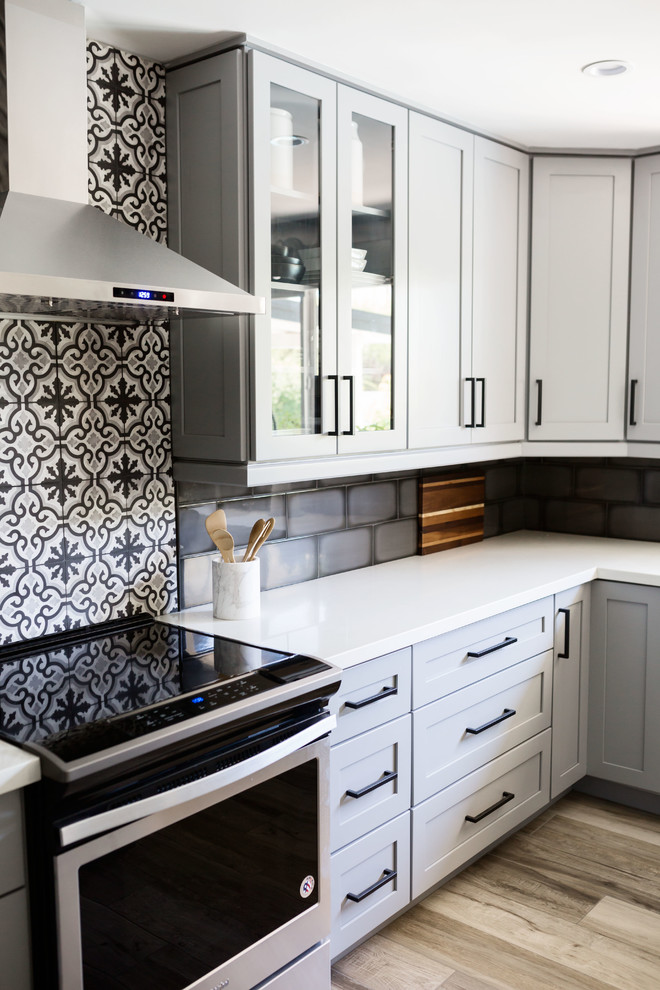 Inspiration for a mid-sized transitional u-shaped light wood floor and gray floor eat-in kitchen remodel in Phoenix with an undermount sink, recessed-panel cabinets, gray cabinets, quartz countertops, multicolored backsplash, ceramic backsplash, stainless steel appliances, an island and white countertops