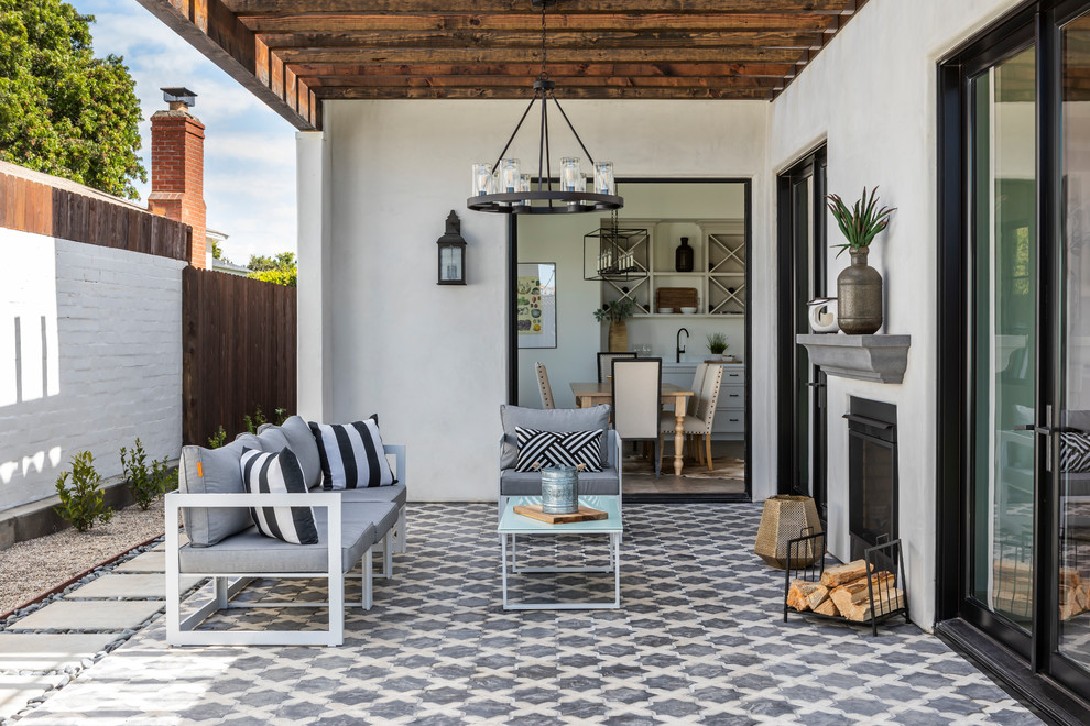 Design ideas for a mediterranean backyard patio in Los Angeles with with fireplace, tile and a pergola.