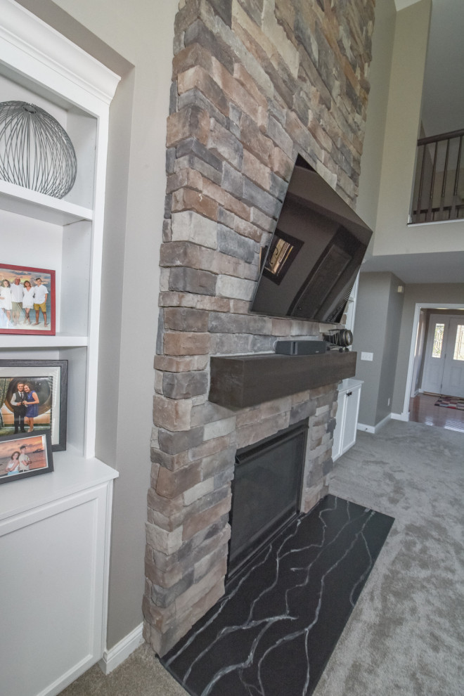 Family room - small craftsman carpeted and beige floor family room idea in Cincinnati with beige walls, a standard fireplace, a stone fireplace and a wall-mounted tv