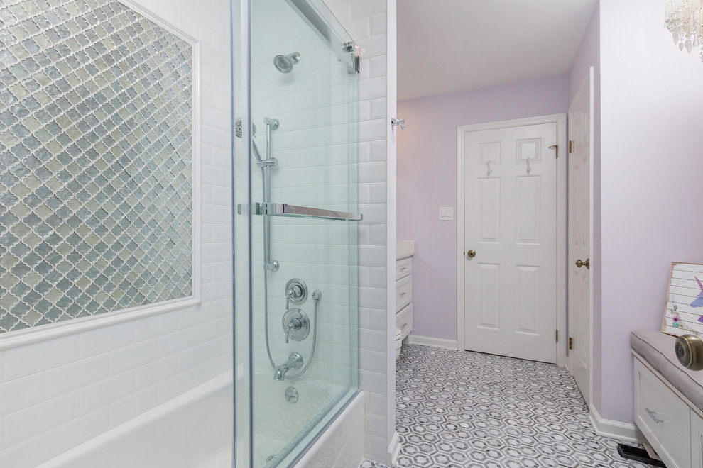 Photo of a mid-sized contemporary kids bathroom in Philadelphia with shaker cabinets, white cabinets, a shower/bathtub combo, purple walls, ceramic floors, an undermount sink and a sliding shower screen.