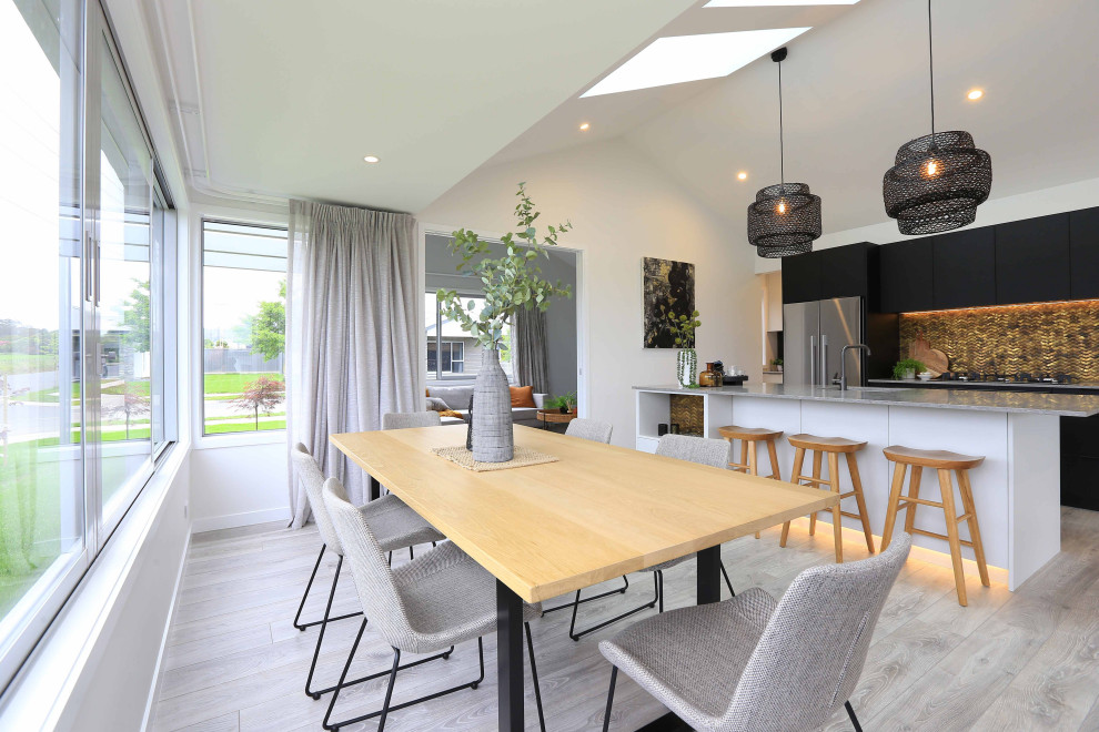 Aménagement d'une salle à manger ouverte sur la cuisine moderne de taille moyenne avec un mur blanc, parquet clair, aucune cheminée, un sol gris, un plafond voûté et du lambris.