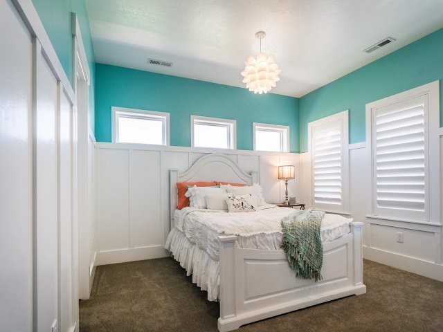 This is an example of a mid-sized transitional guest bedroom in Salt Lake City with blue walls and carpet.