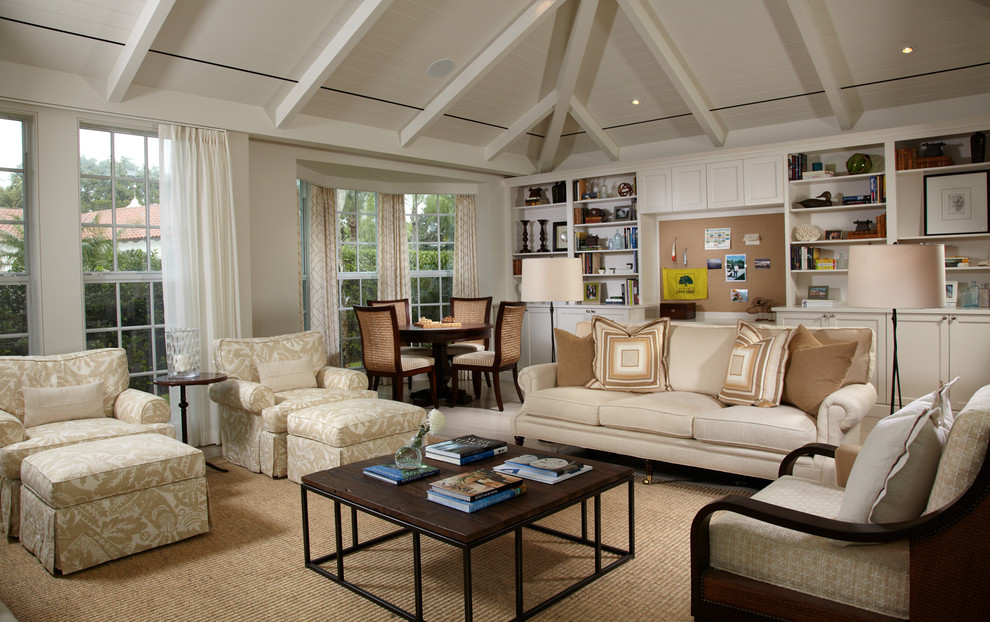 This is an example of a large traditional family room in Miami with white walls, light hardwood floors and a wall-mounted tv.