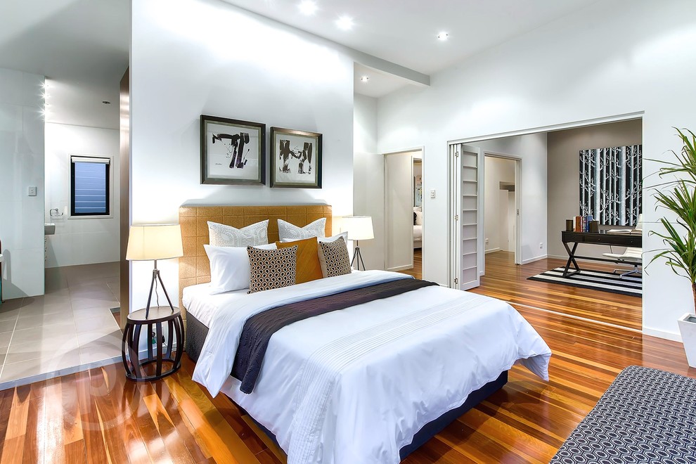 Design ideas for a large transitional master bedroom in Brisbane with white walls and medium hardwood floors.