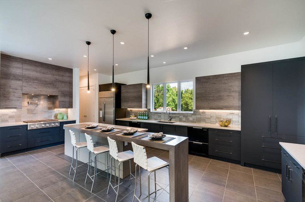 Photo of a large contemporary u-shaped open plan kitchen in Denver with an undermount sink, flat-panel cabinets, quartz benchtops, metal splashback, stainless steel appliances, porcelain floors, grey floor, black cabinets, metallic splashback and multiple islands.